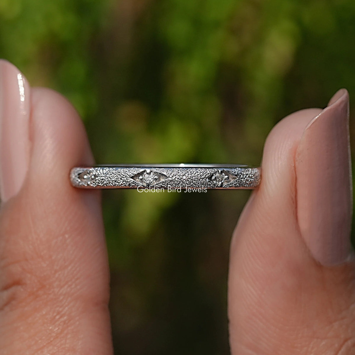 Silver eternity band with round moissanite-like stones, glittering straight-on view
