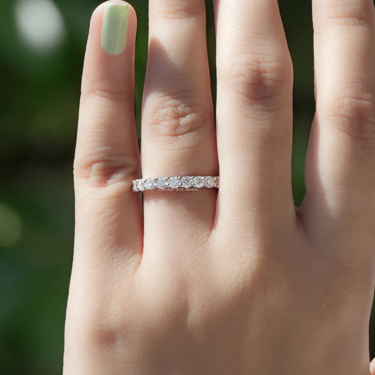 Silver half-eternity ring with a row of round-cut stones across the top