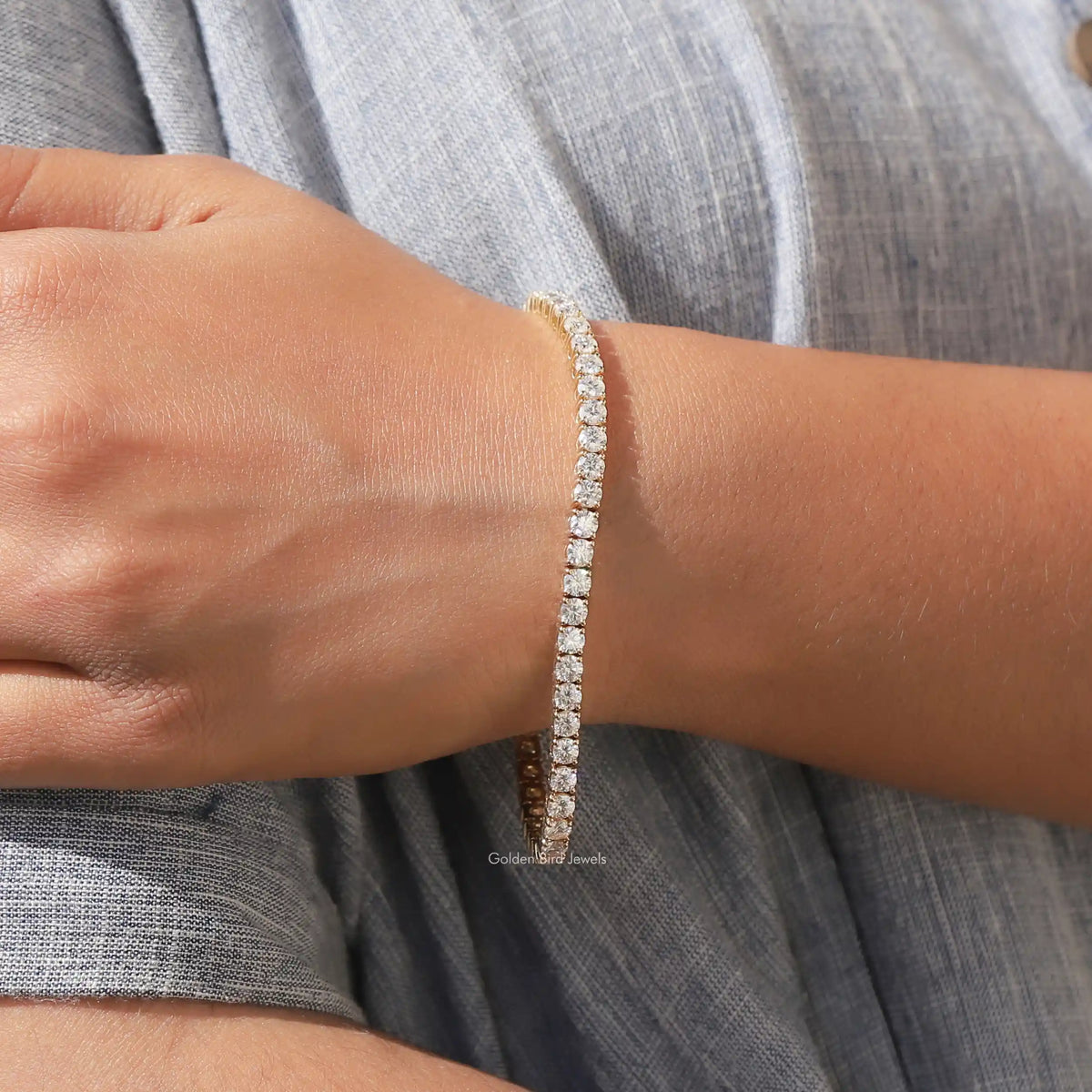 Moissanite tennis bracelet with round-cut stones, gold-tone, close to wrist