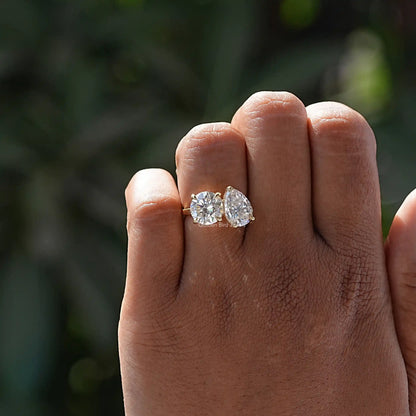 Moissanite toi et moi ring on hand with pear-cut and round stones