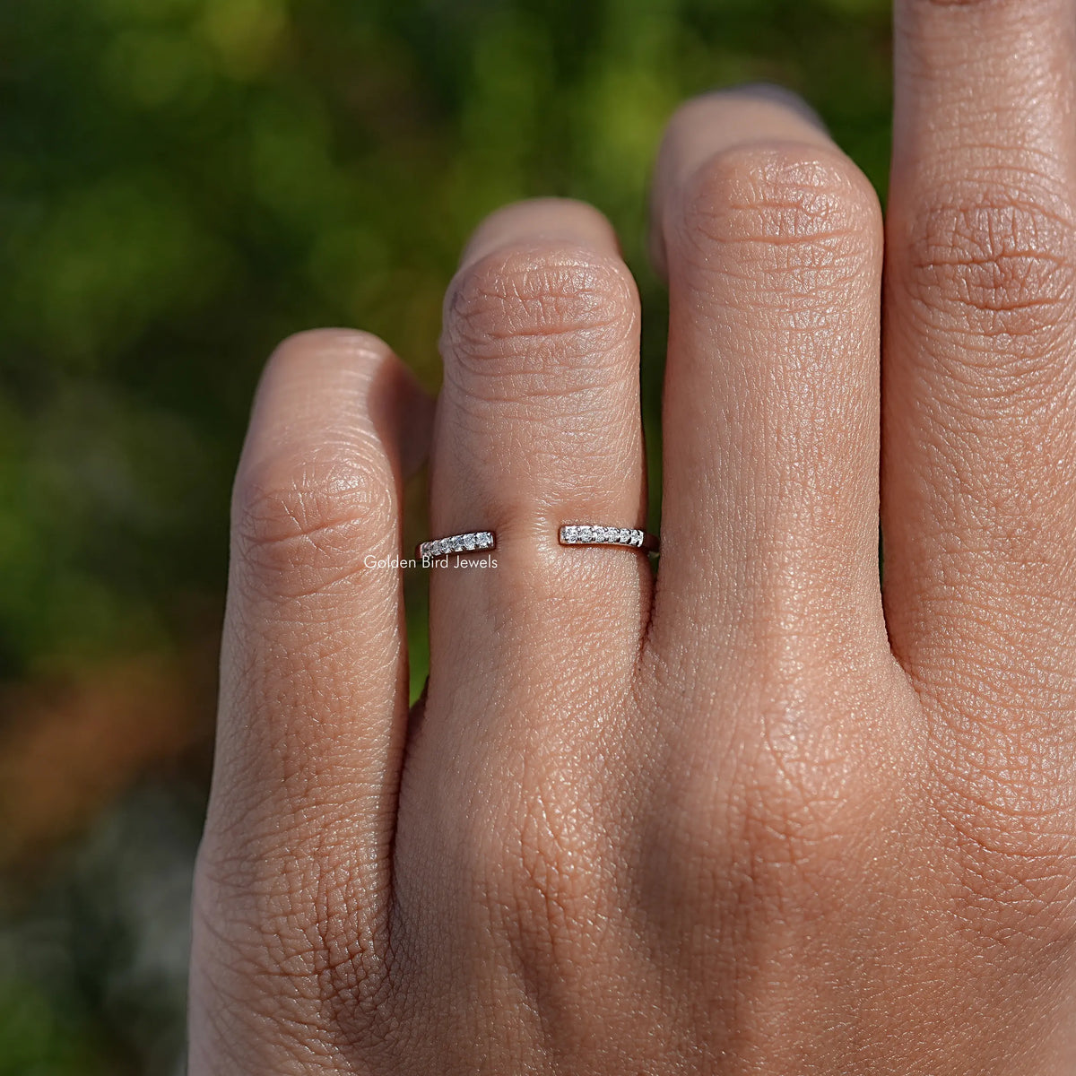 Round moissanite open cuff band ring on a hand