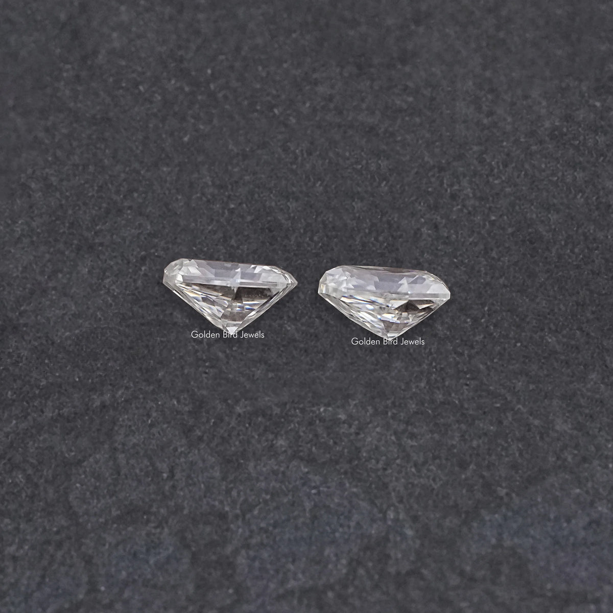Shield-cut moissanite gemstones pair, clear shield-cut stones, two pieces side by side
