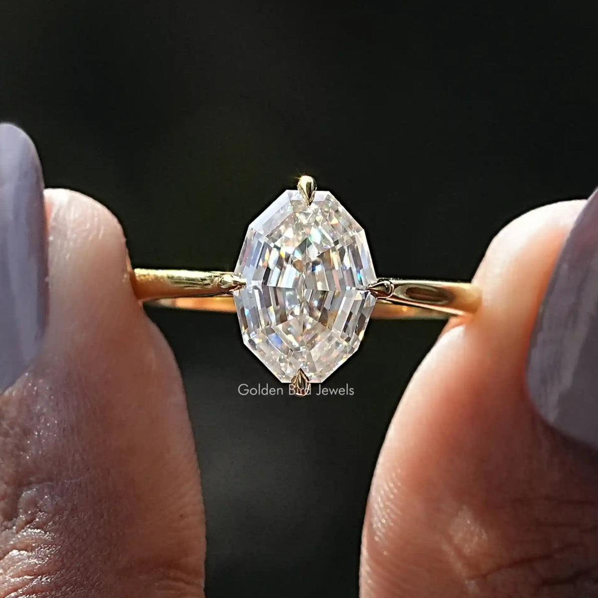 Two fingers holding the Step Cut Oval Hidden Halo Engagement Ring