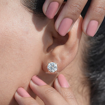 Round moissanite stud earrings on ear, gold-tone bezel and push-back shown