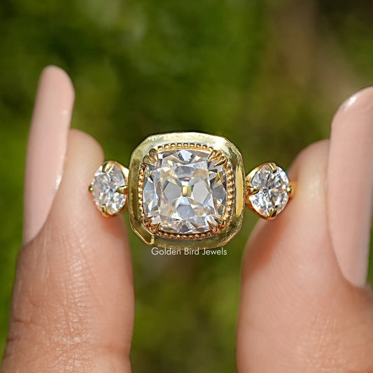 Three-stone cushion moissanite ring front view, halo center with round side stones