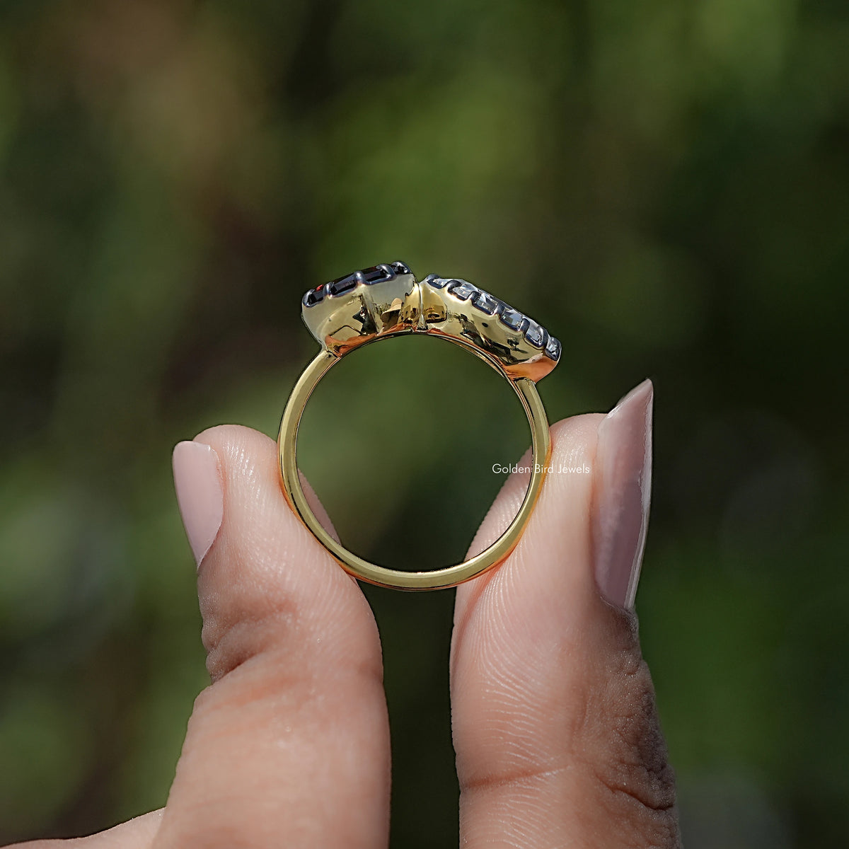 Back view of heart two-stone ring with dark gemstones on silver-toned band
