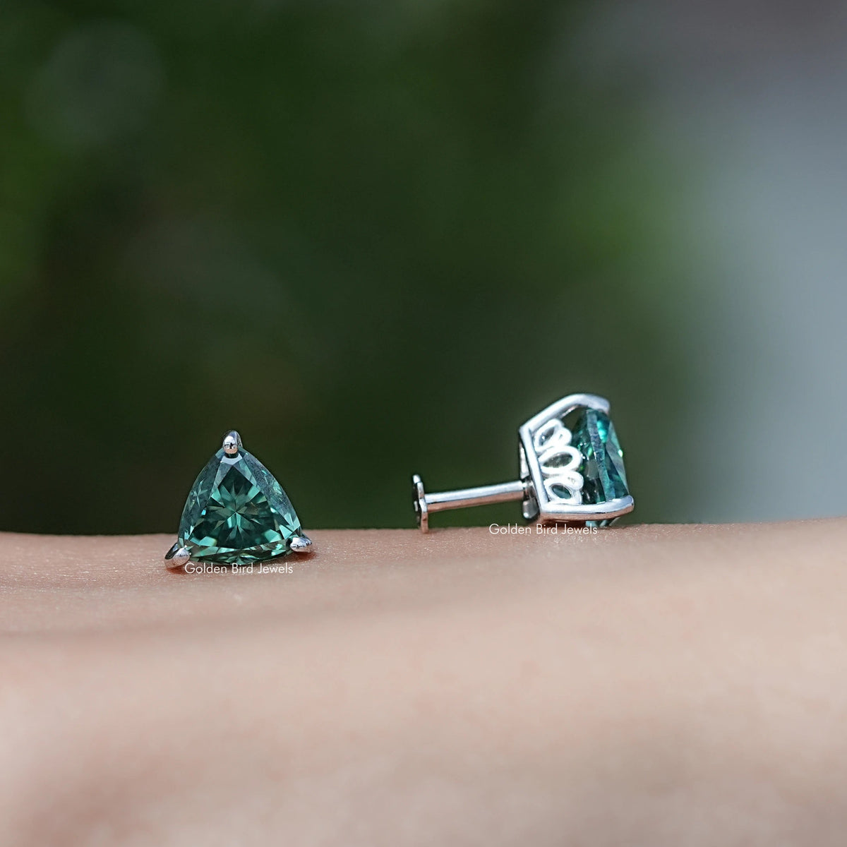 Dark green trillion-cut moissanite stud earrings with visible back post