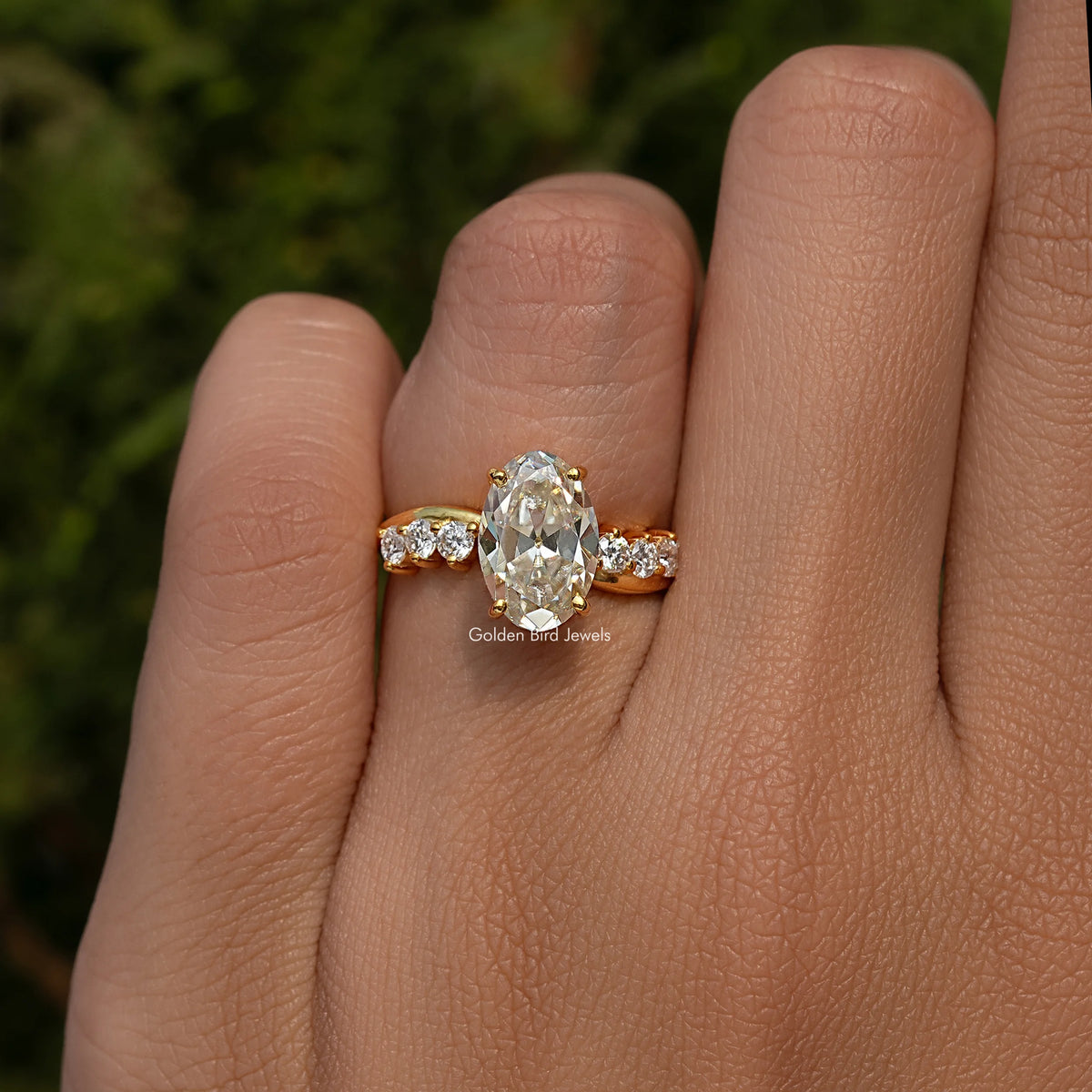 Gold-tone infinity ring with oval old mine center stone and three round accent stones
