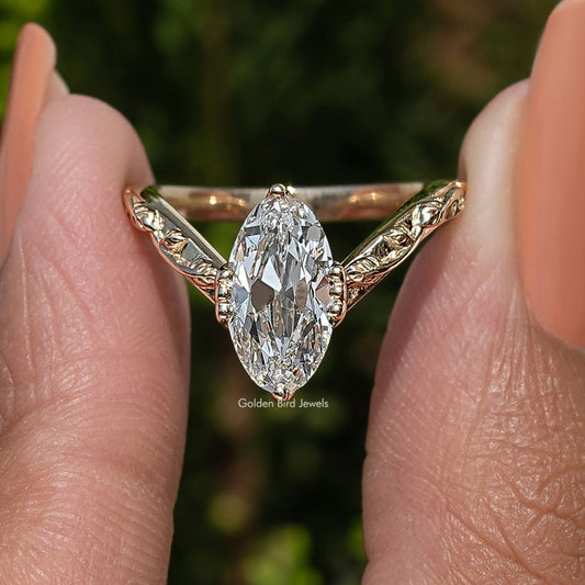 Curved diamond ring with large oval center stone and gold-tone side prongs