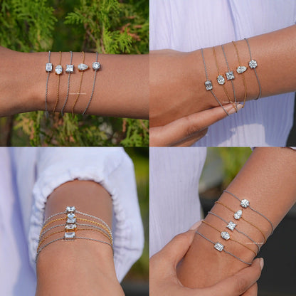 Multiple stacked bracelets on wrist, silver and gold-tone chains with assorted moissanite