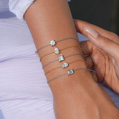 Silver and gold-tone chain bracelets with four assorted moissanite charms on wrist