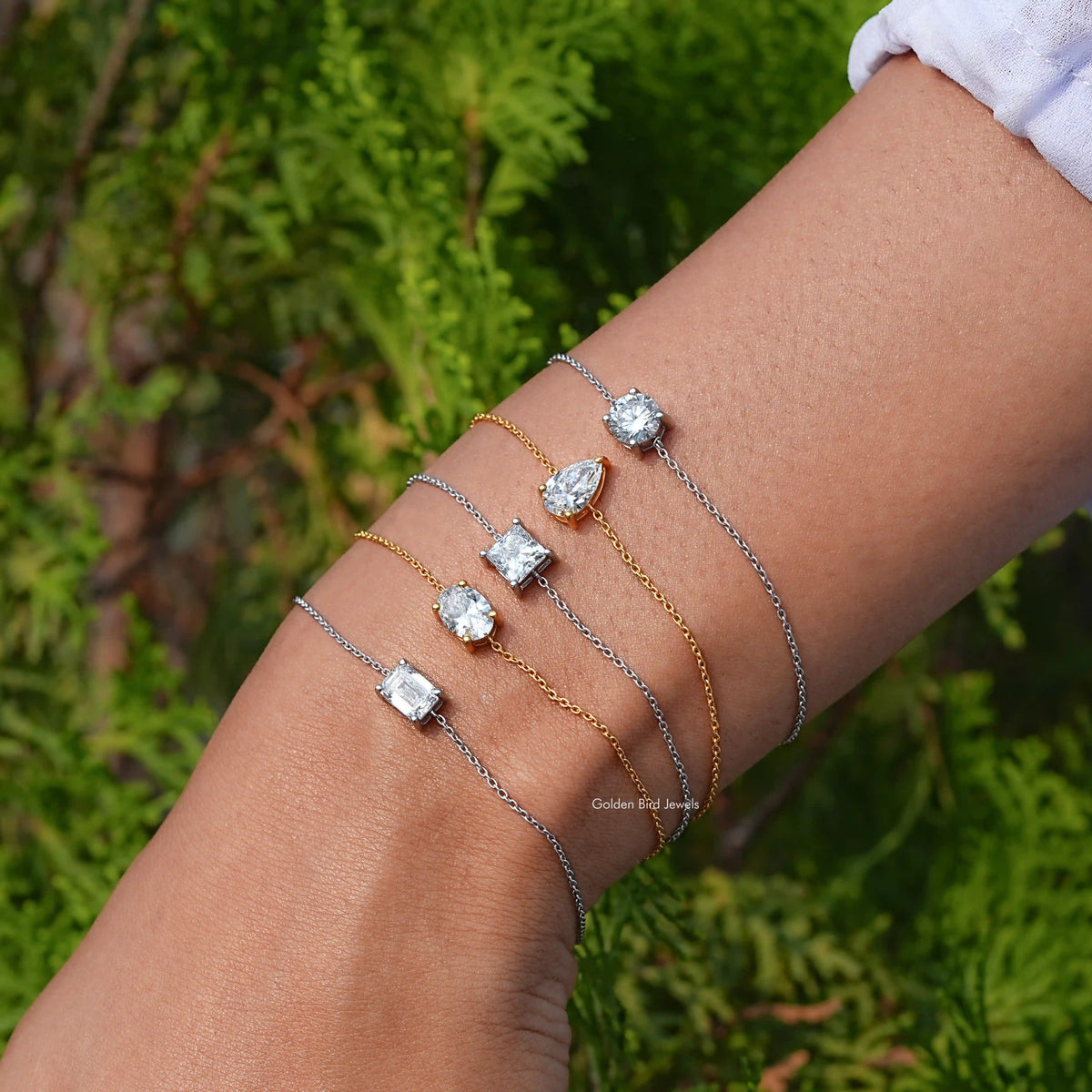 Silver and gold-tone chain bracelet with round moissanite charms and one square charm