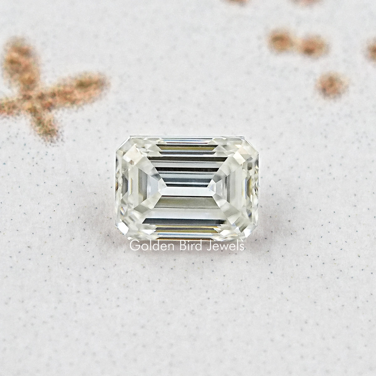 Close-up emerald-cut moissanite loose stone with rectangular step-cut facets