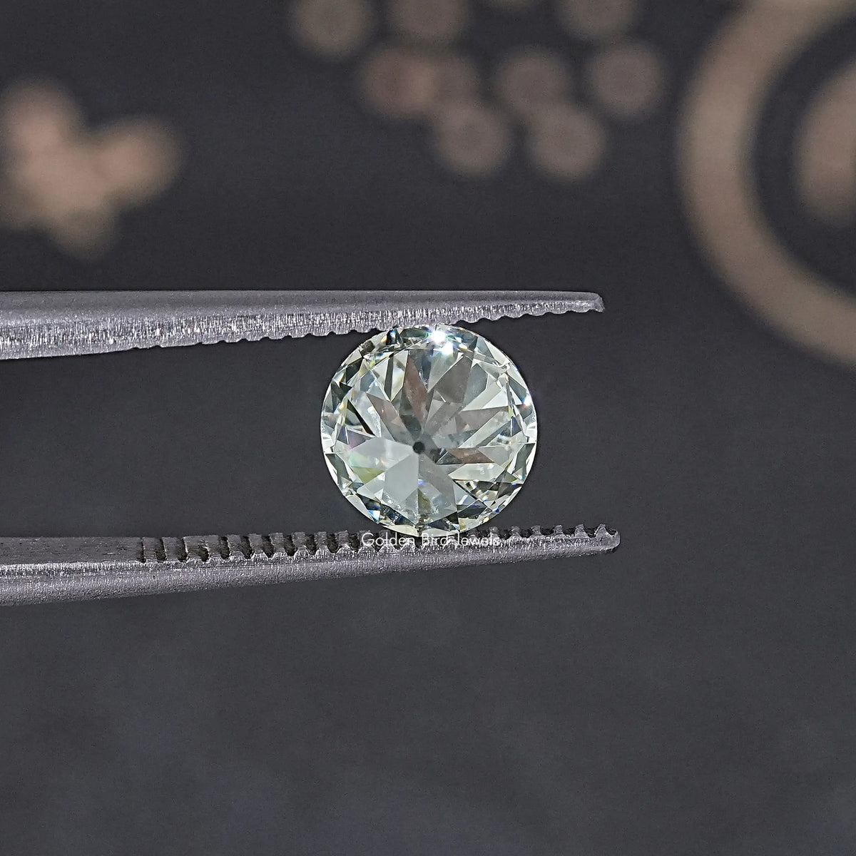 Old European round loose lab diamond held in silver tweezers, clear brilliance