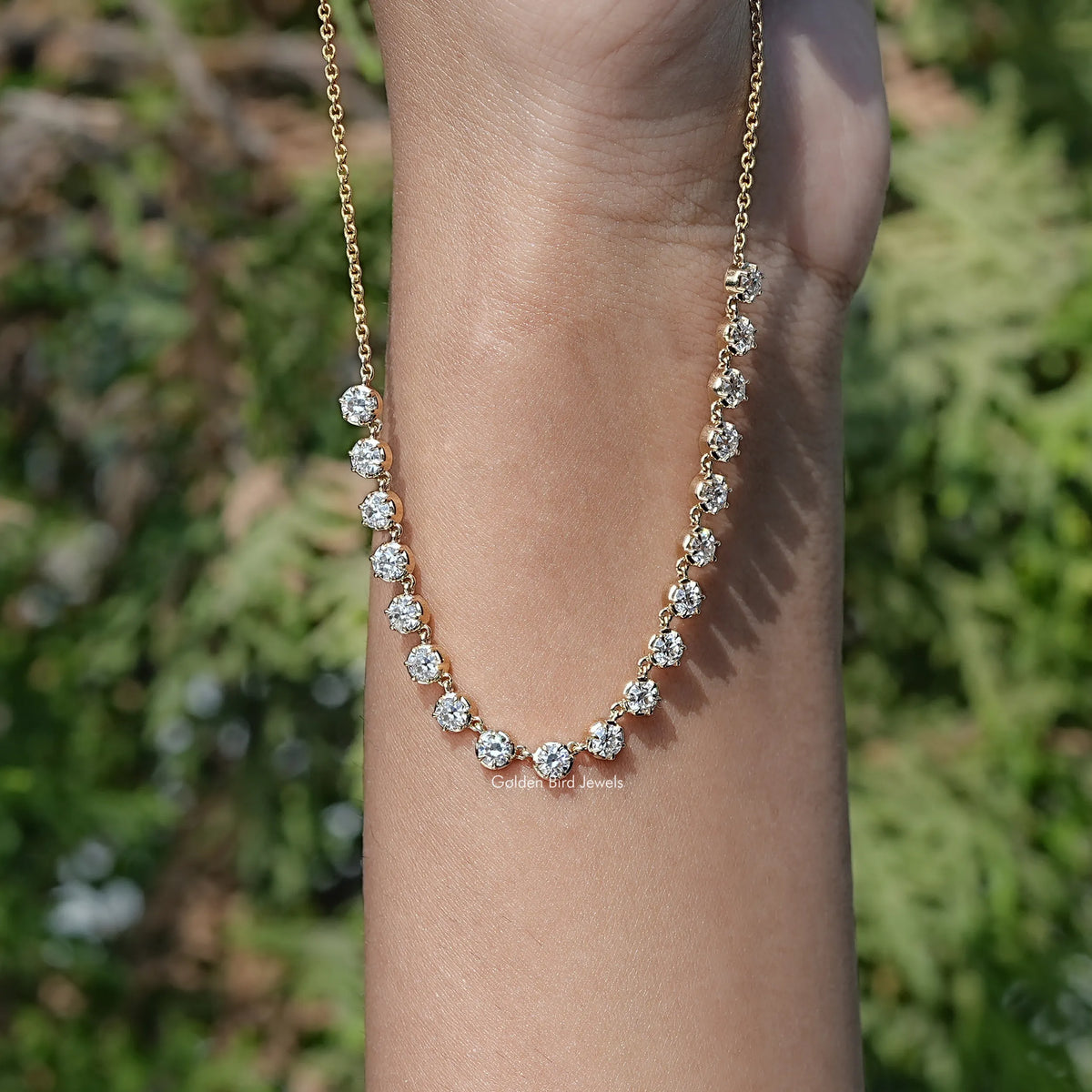 Gold-tone round-cut moissanite tennis necklace with repeating stones along chain