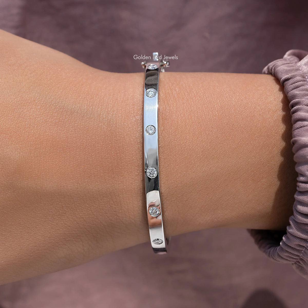 Silver lab diamond flush-set bangle, close-up on wrist with round stones