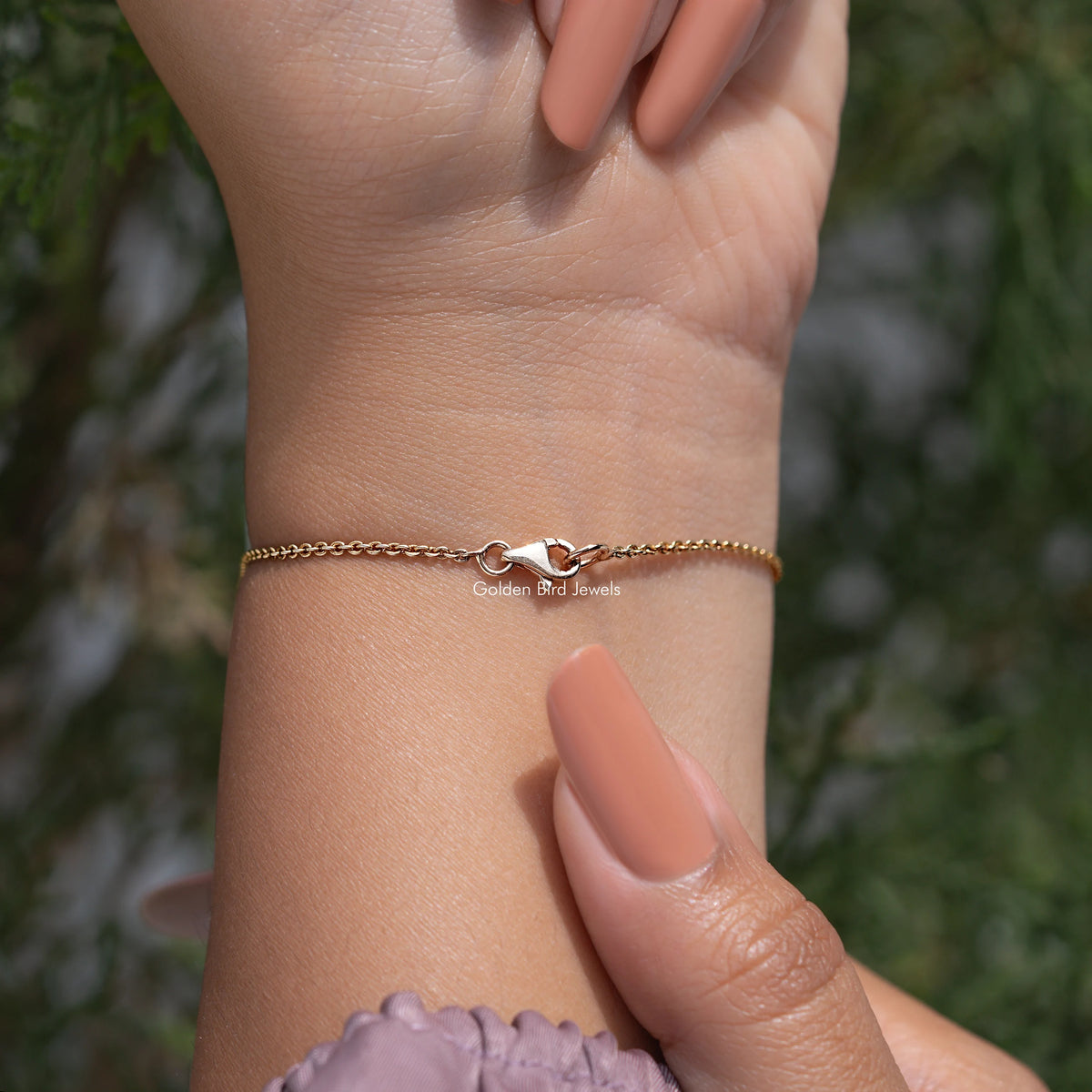 Gold chain bracelet worn on wrist, no stones visible in this view
