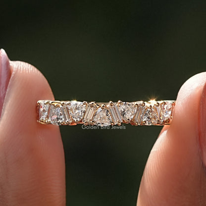 Trillion and Baguette Diamond Eternity Wedding Band Held Between Fingers