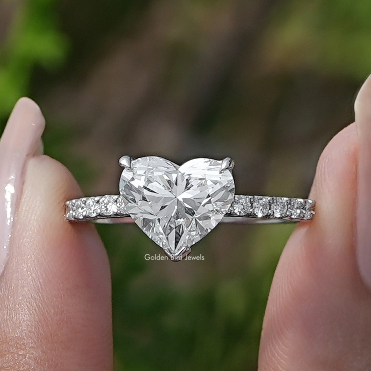 Heart Shaped Diamond Solitaire Ring Held Between Fingers