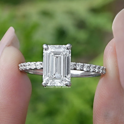 Emerald Cut Diamond Solitaire Ring Held Between Fingers