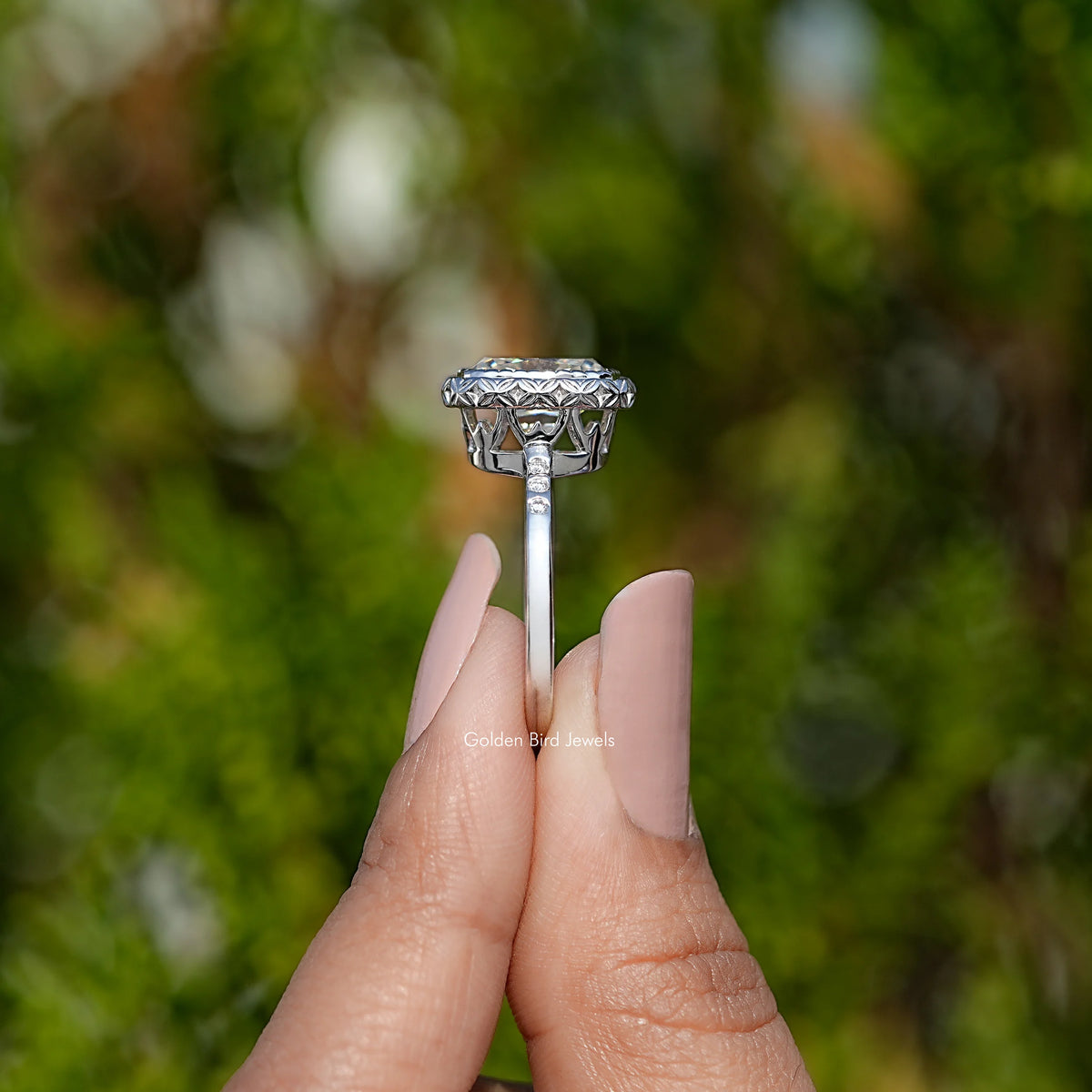 Silver cushion-cut moissanite ring viewed from side, halo prongs visible