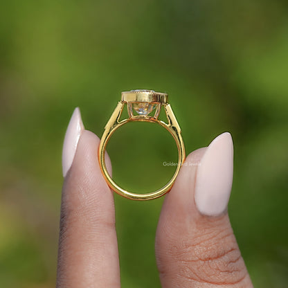 Gold moissanite ring viewed from side, square milgrain bezel setting
