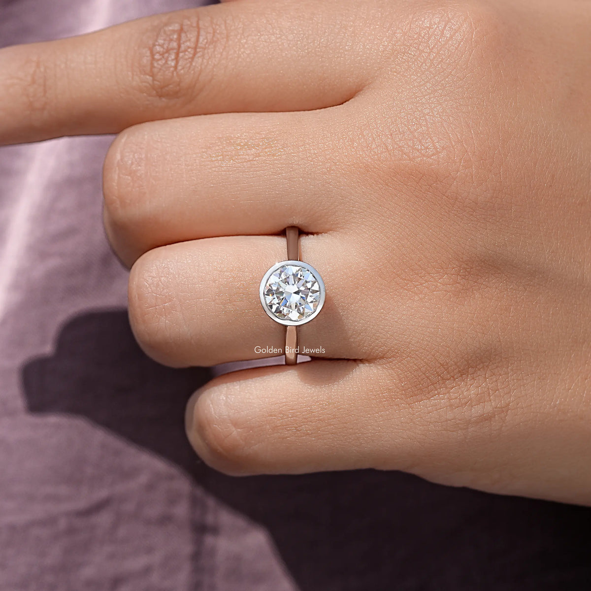 Sterling silver round moissanite bezel wedding ring, centered stone on fingertip