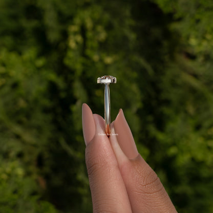Side view of round moissanite ring showing prongs and slim gold-tone band