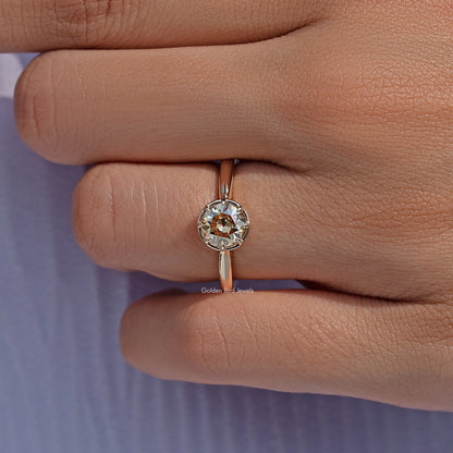 Prong-set round moissanite ring with gold-tone band, worn with stone centered