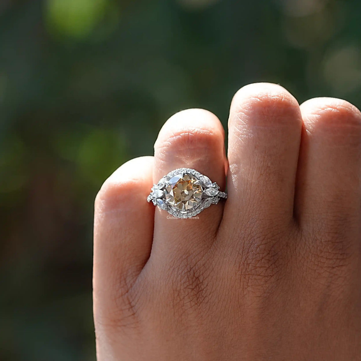 Silver halo cluster ring with round champagne center stone, fingers wearing it
