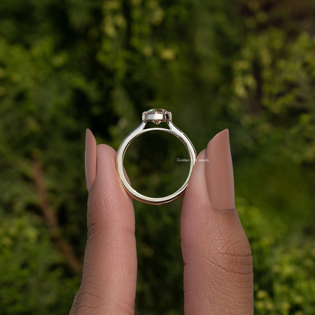 Round moissanite ring with gold-tone band and prong-set center stone, top view