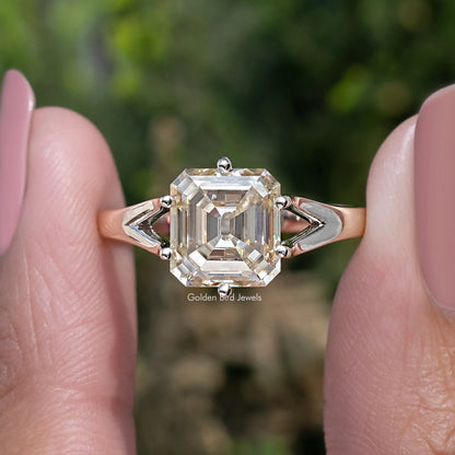 Yellow asscher-cut moissanite ring close-up with split shoulders and four-prong setting