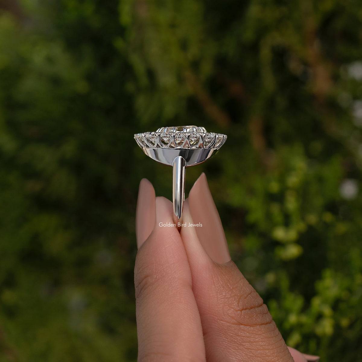 Sterling silver double halo cushion moissanite ring, side view on fingertip