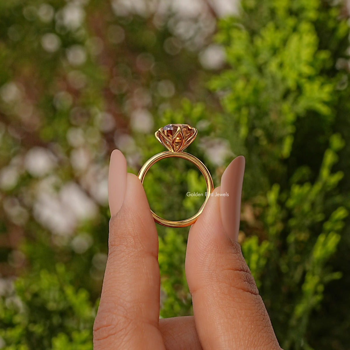 Gold tone engagement-style ring with cushion-cut solitaire gemstone, front view