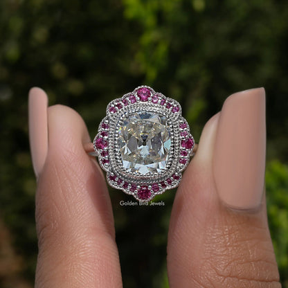 Sterling silver halo ring with cushion-cut moissanite center and pink stone border