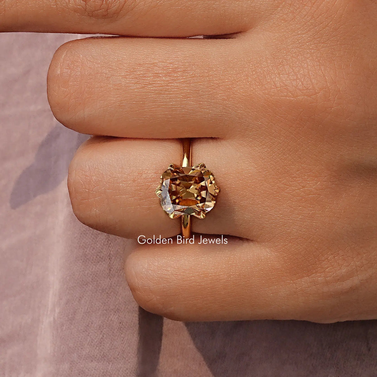 Gold tone solitaire ring with cushion-cut gemstone and four-prong setting