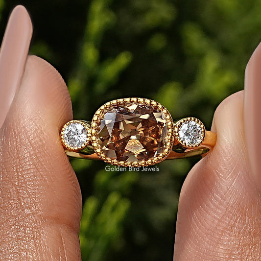 Yellow gold three-stone ring with cushion-cut center and two round side diamonds