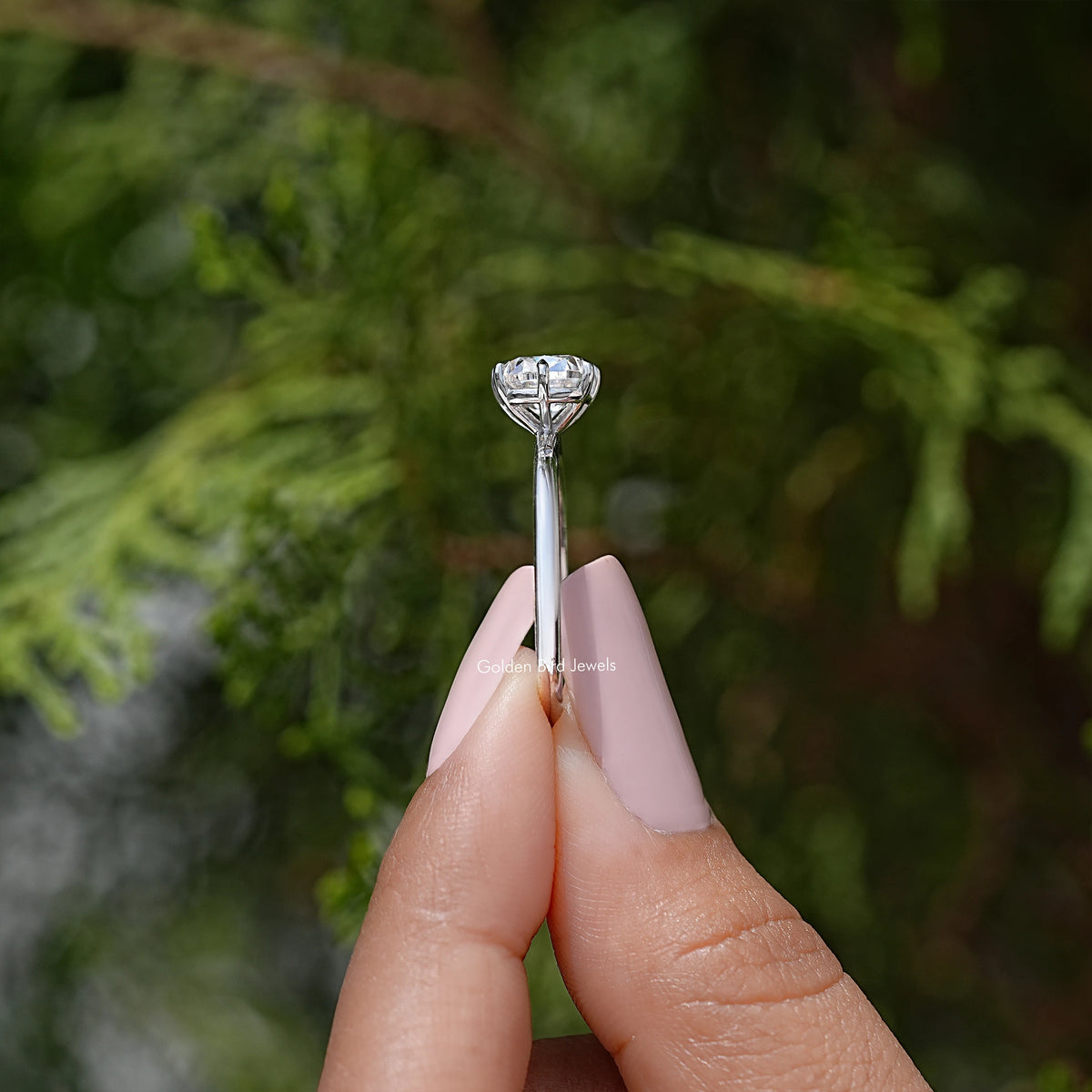 Silver engagement-style ring viewed from the side with cushion-cut center