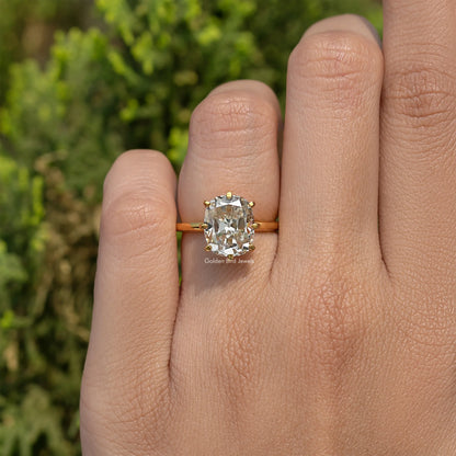 Gold-tone cushion solitaire engagement ring with large square-cut center stone, on finger