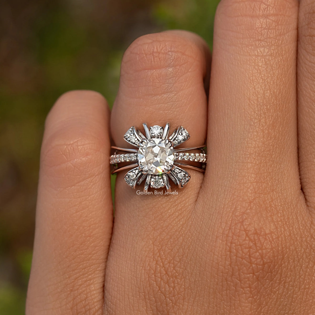 Moissanite ring with cushion-cut center stone, floral halo, and pavé band on a hand