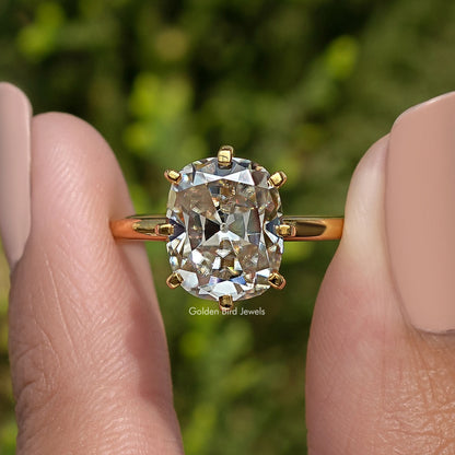 Gold-tone cushion solitaire ring showing square center stone and four-prong setting, front view