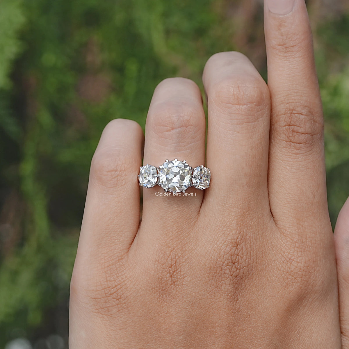 In finger front view of Old Mine Cushion Three Stone Moissanite Ring
