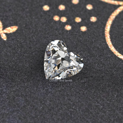 Loose heart-cut diamond with crisp brilliant facets on dark velvet