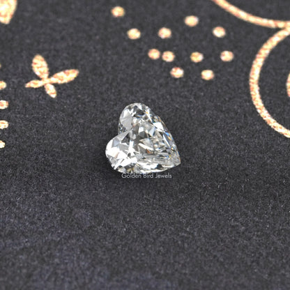 Loose heart-cut diamond with sparkling facets on dark jewelry backing