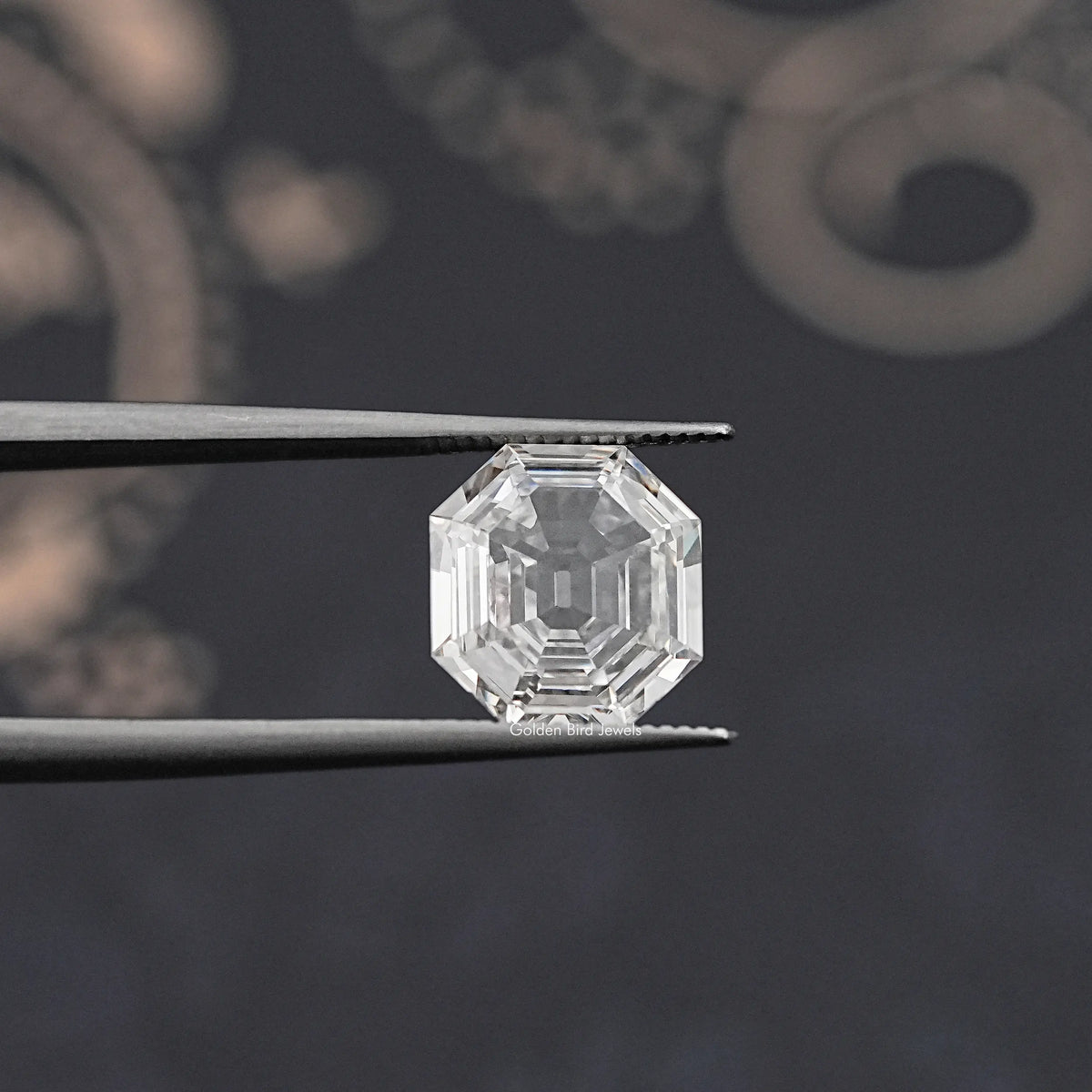 Lab-grown diamond old mine hexagon cut, held between metal tweezers