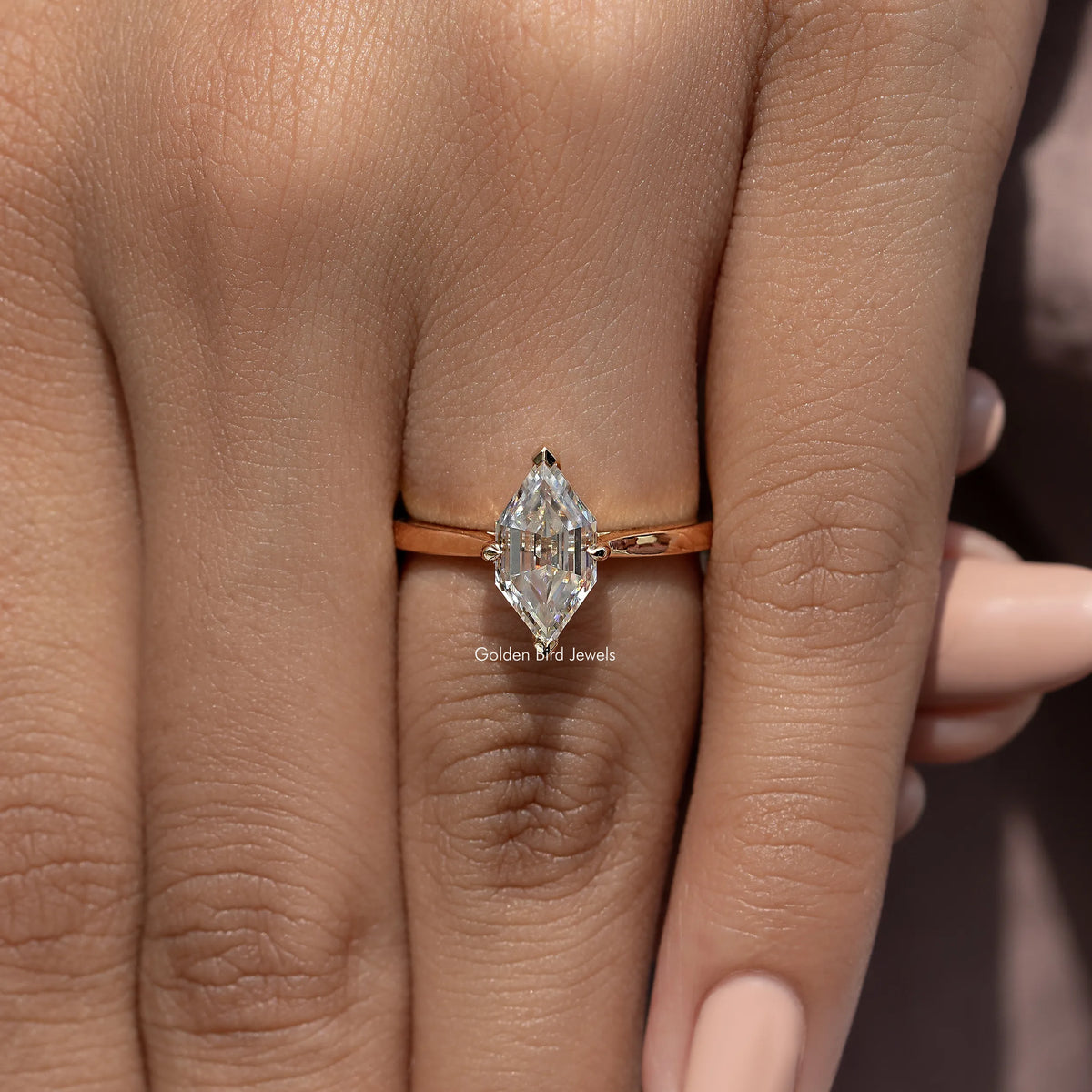 Gold-tone ring with marquise step-cut moissanite center stone, slim band