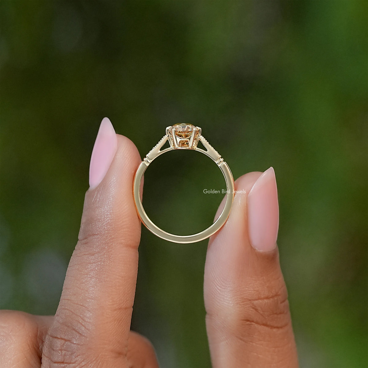 Gold-tone oval solitaire ring with raised center stone and square prongs