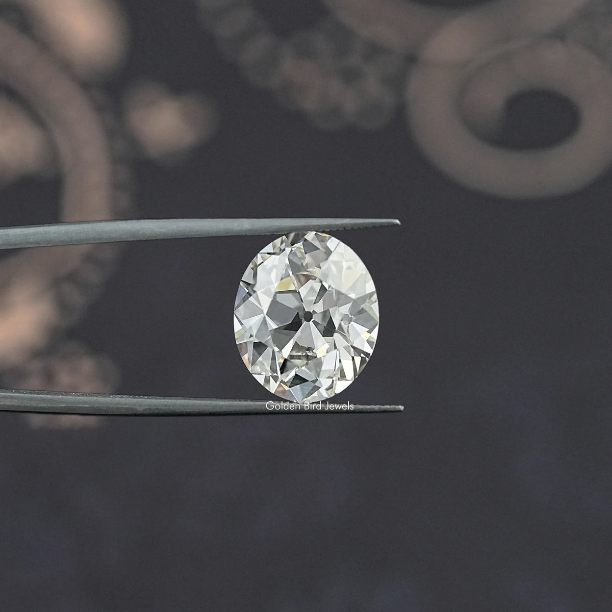 Oval-cut lab-grown diamond held in tweezers, old mine style face view