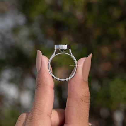 Bezel-set solitaire ring with round band and dark green step-cut stone, top view