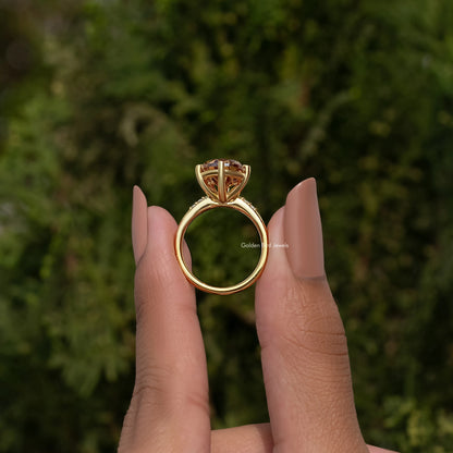 Gold engagement ring with pear-cut center stone and small side accents